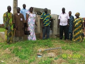 2009 Dr. Ojebode (center) and the hospital staff celebrates the completion of the project. The pipes from the borehole that feeds the system are coming out of the ground in front of the staff