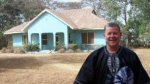 Ron Wassom in front of blue house